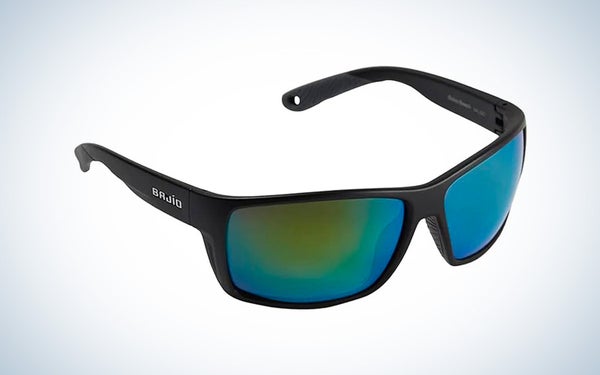 A black framed pair of Bajio sunglasses with green and blue lenses on a black and white gradient background.