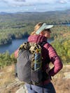 a hiker with a loaded backpack on overlooking a lake in the woods