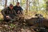 Two hunters admire a big whitetail buck in a Missouri woodlot.