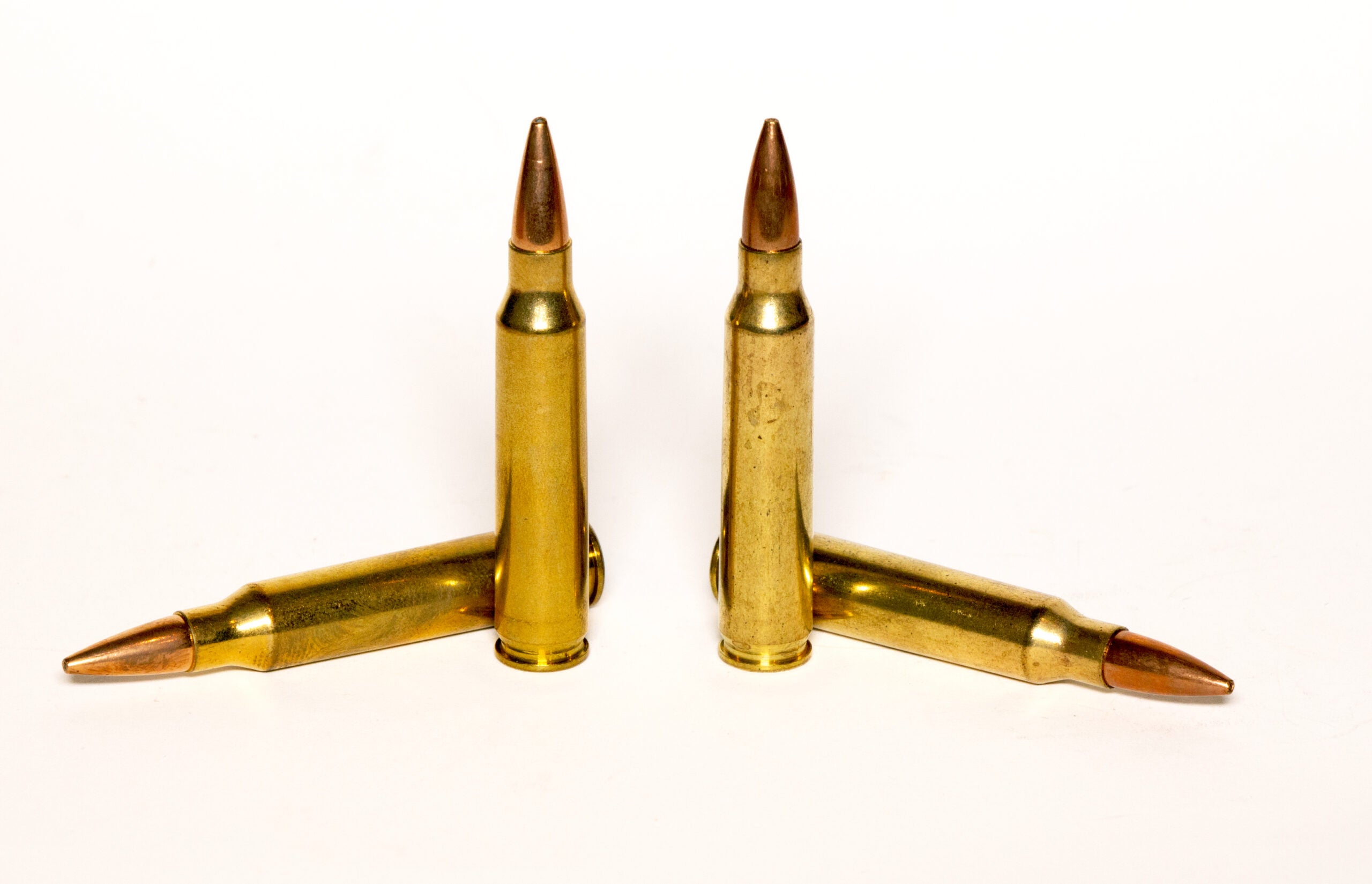 Two 556 cartridges on the left, standing next to two 223 cartridges on the right.