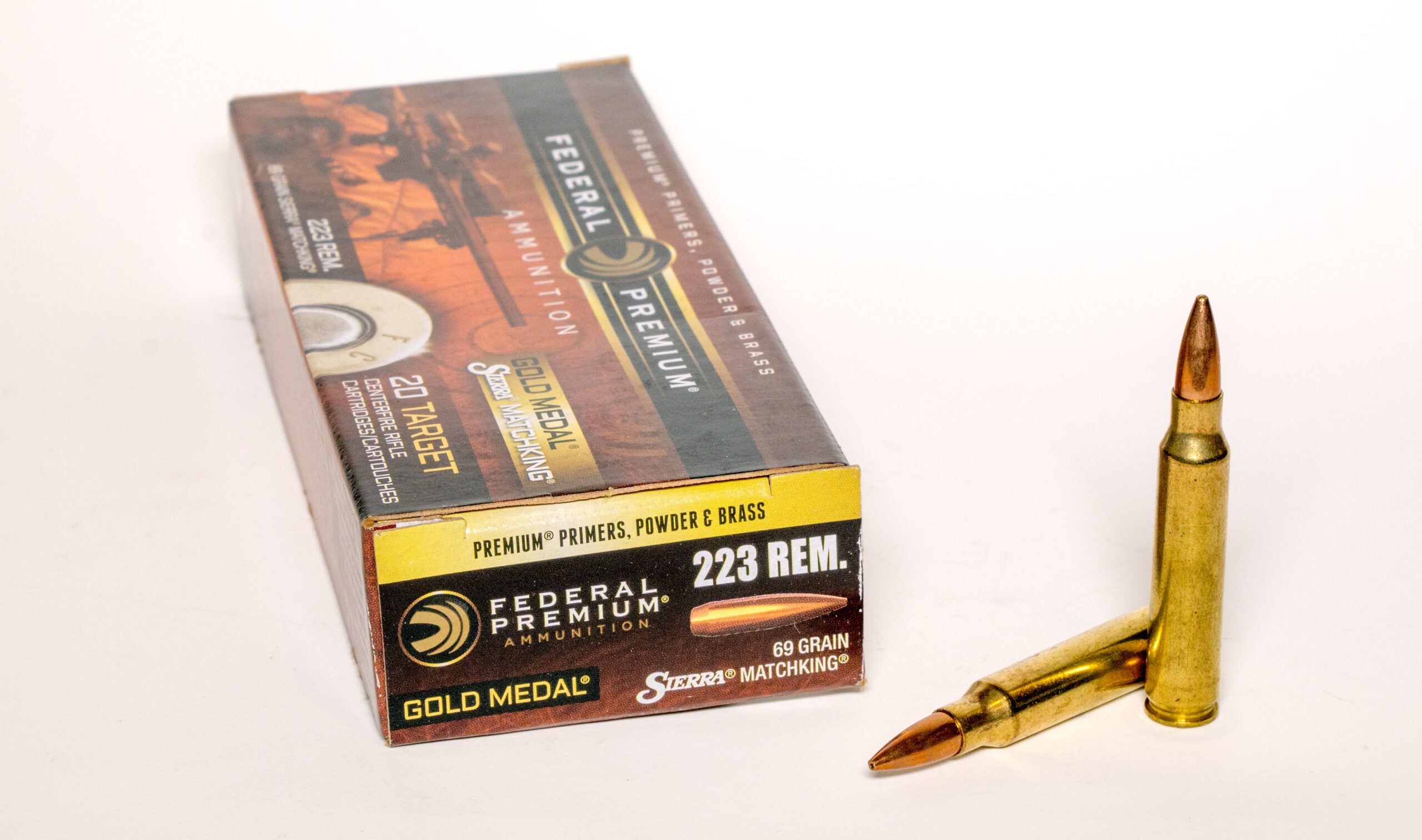 A box of 223 Rem ammo on a white background with two cartridges next to it.