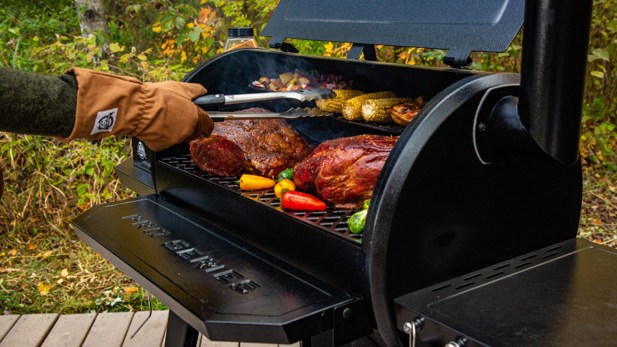Man grilling meat and vegetables on Pit Boss Pro Series Pellet Grill and Smoker