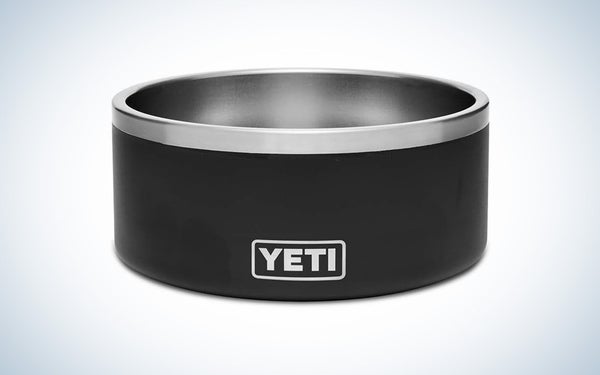 A black and stainless steel Yeti dog bowl on a black and white gradient background.