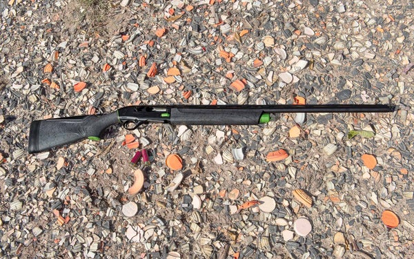 Beretta A300 Ultima Sporting shotgun lying on the ground at a clay target range.