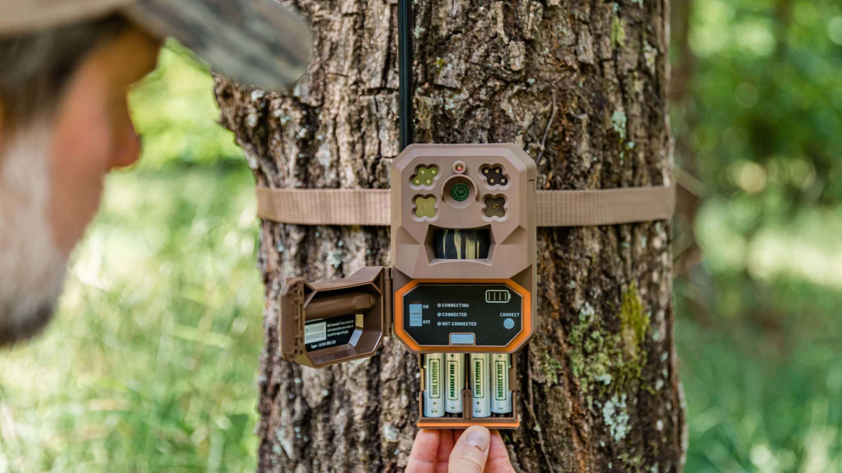 Man changing batteries on Moultrie Mobile Edge Cellular Trail Camera