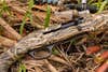 Close-up of Tristar Matrix shotgun on the ground with marsh grass and a duck call.