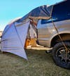 Kelty Caboose 4 SUV Tent set up on back of Ford Excursion