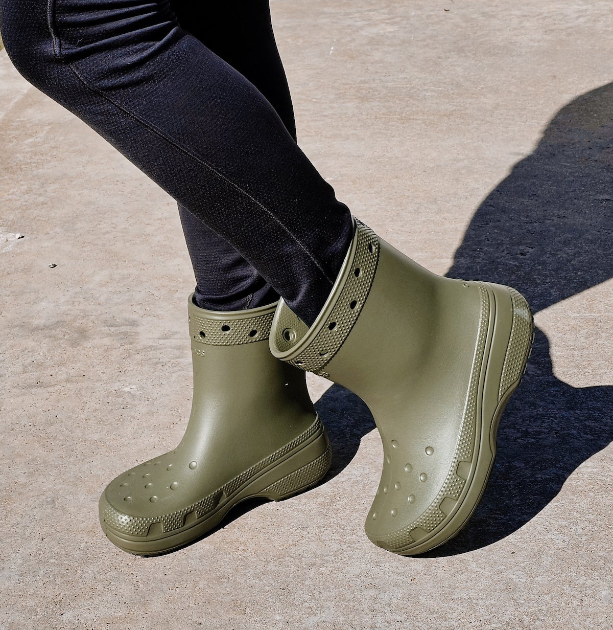 Woman wearing olive green Crocs classic rain boots