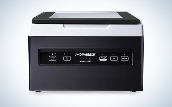 A black and white Avid Armor chamber vacuum sealer on a black and white gradient background.