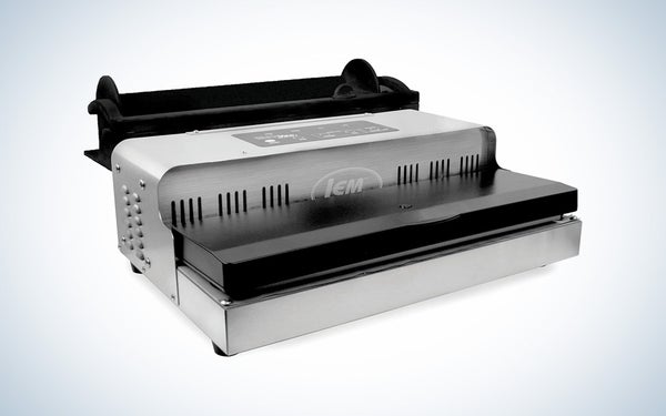 A silver and black LEM commercial grade vacuum sealer on a black and white gradient background.