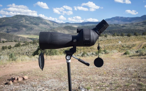 Bushnell Engaged DX spotting scope on tripod with mountains in the background