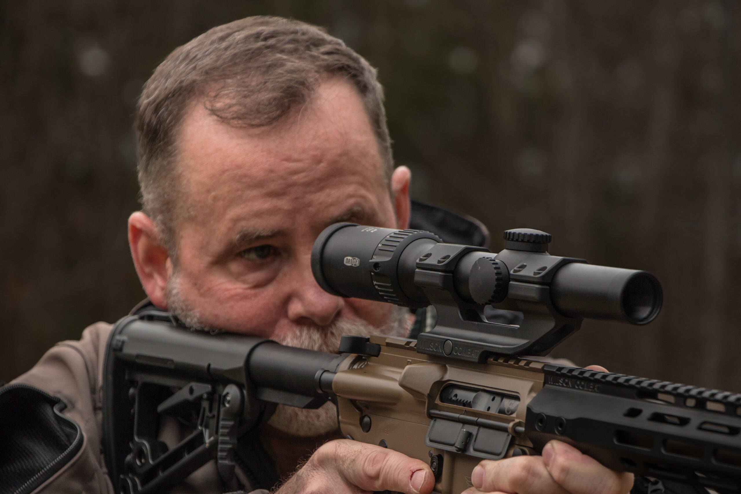 A shooter aims through the scope of an AR-15 rifle chambered for 556 NATO