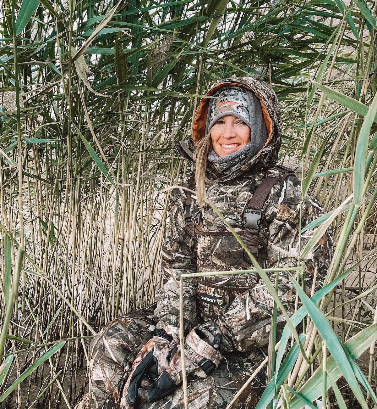 Female duck hunter wearing DSG Kylie Jacket in marsh