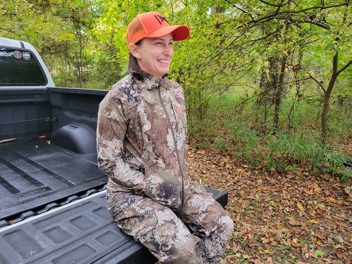 Female hunter wearing Ditale Becca Adventure jacket on bed of pickup truck