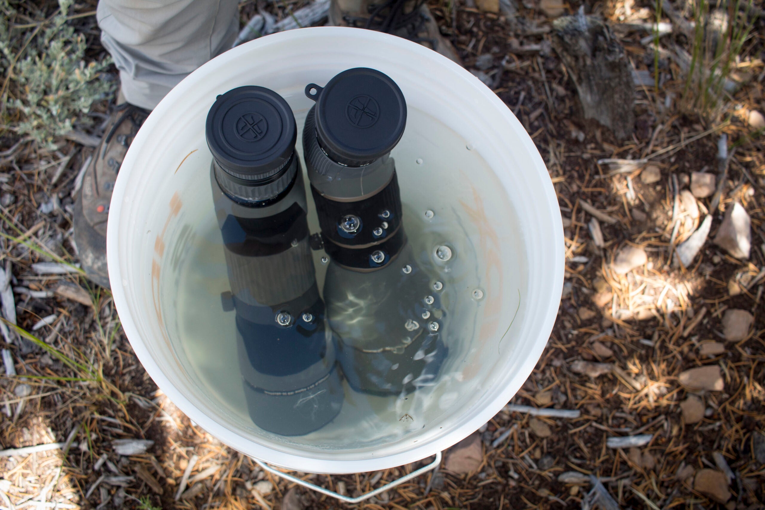 two spotting scopes in a bucket of water