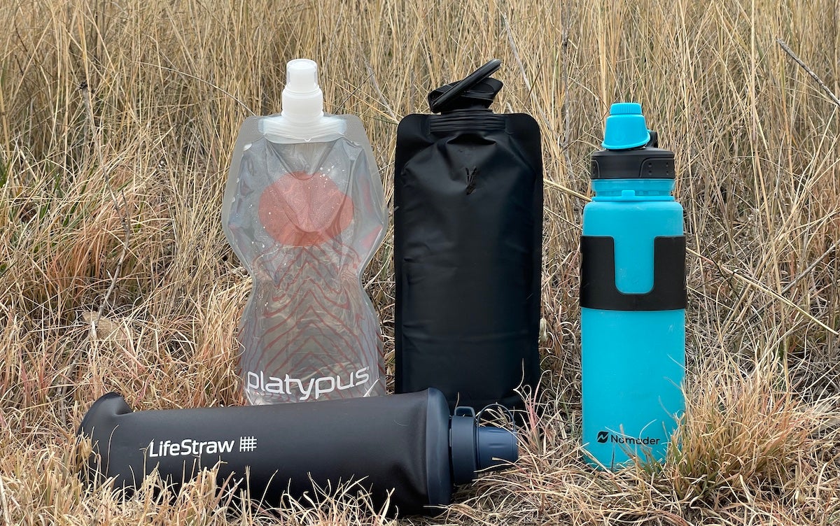 Collapsible water bottles lined up in grass