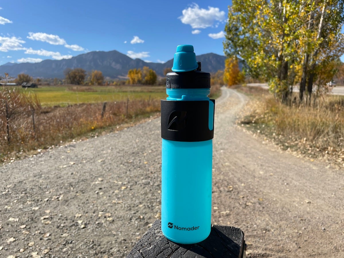Nomader Collapsible Water Bottle sitting on dirt trail
