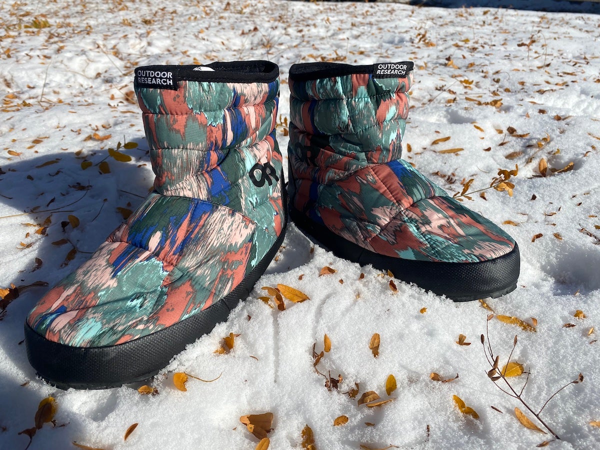 Outdoor Research Tundra Trax Booties sitting on snowy ground