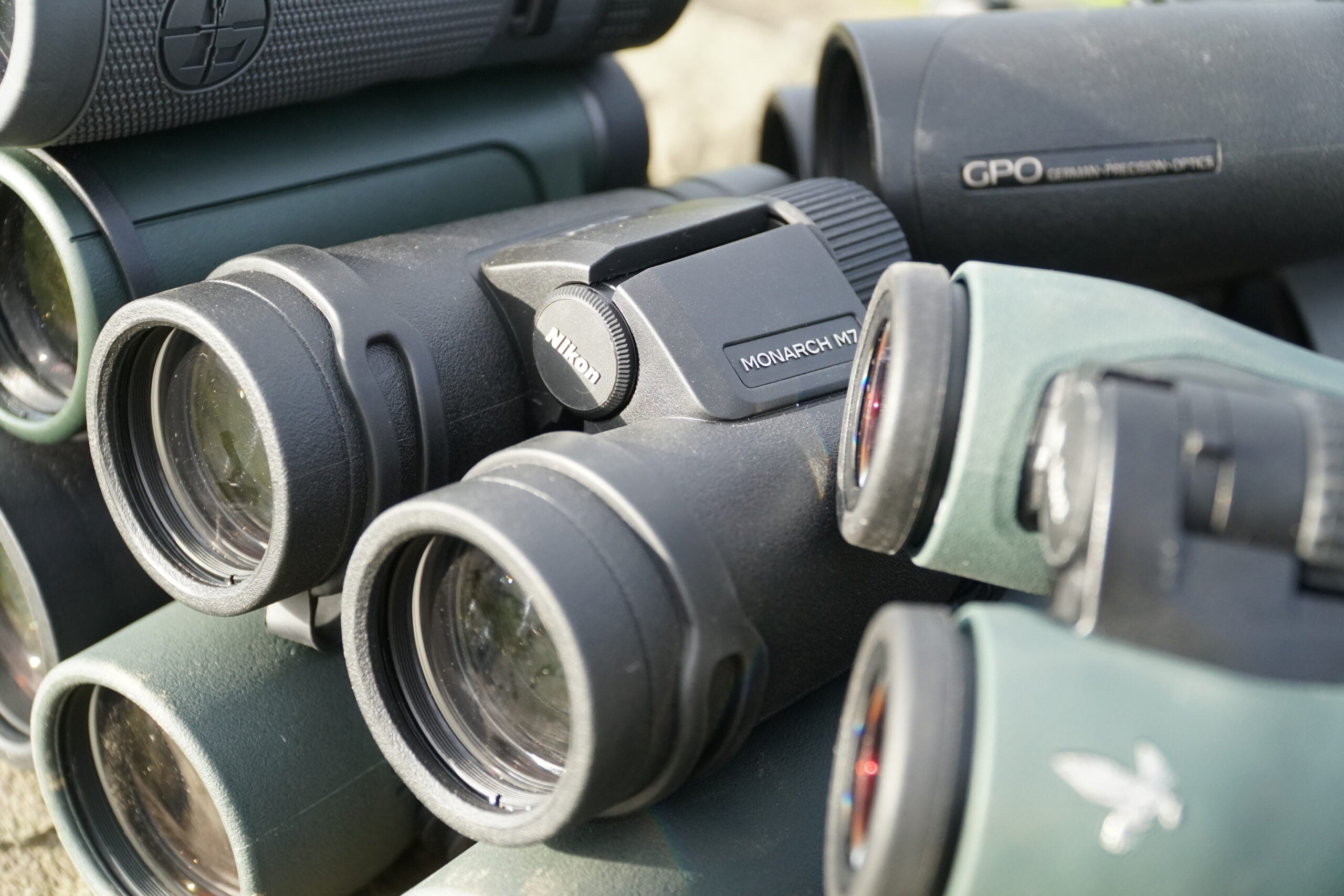 Nikon Monarch M7 10x42 binocular resting among other binoculars being tested.