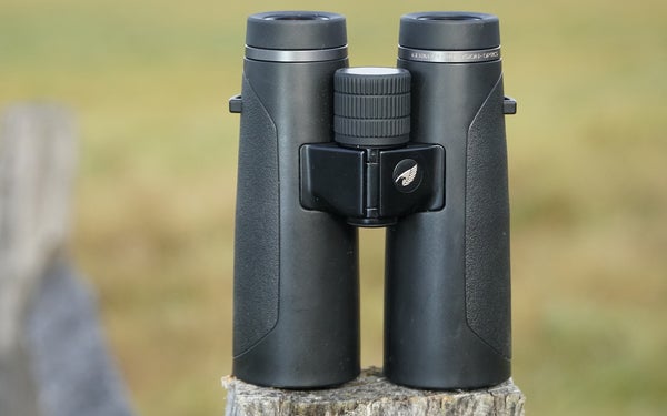 GPO Passion HD 10x42 binocular sitting on a fence post with field in background