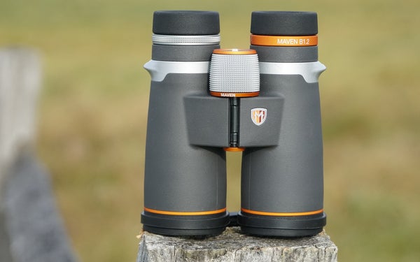 Maven B1.2 10x42 binocular sitting on a fence post with field in background.