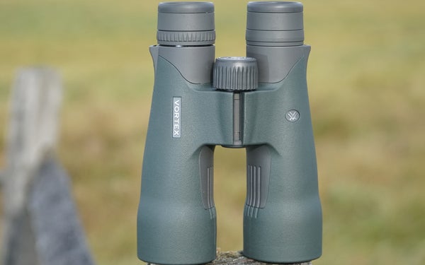 Vortex Razor UHD 10x50 binocular sitting on a fence post with field in background