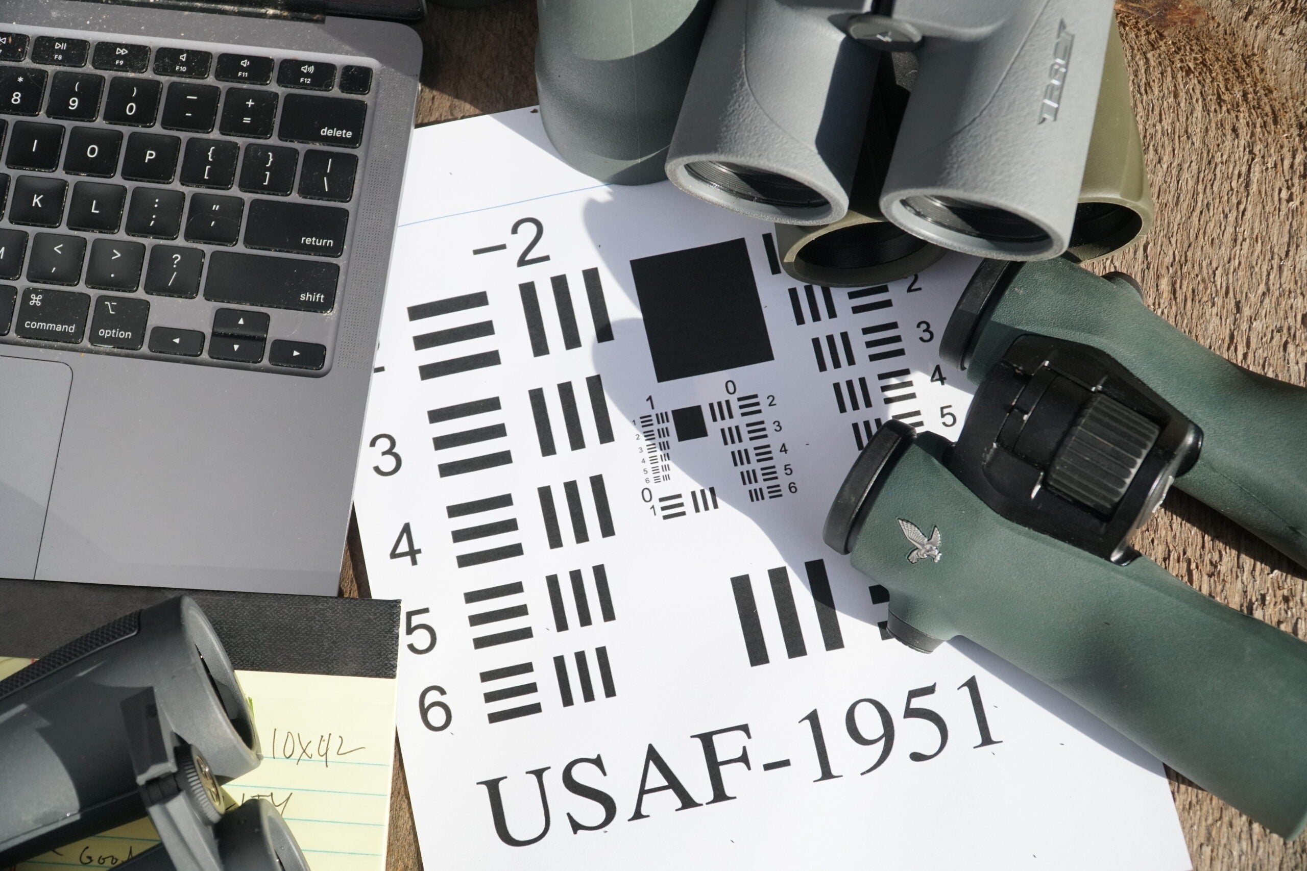 A SSAF-1951 resolution chart on a table with computer and binoculars.