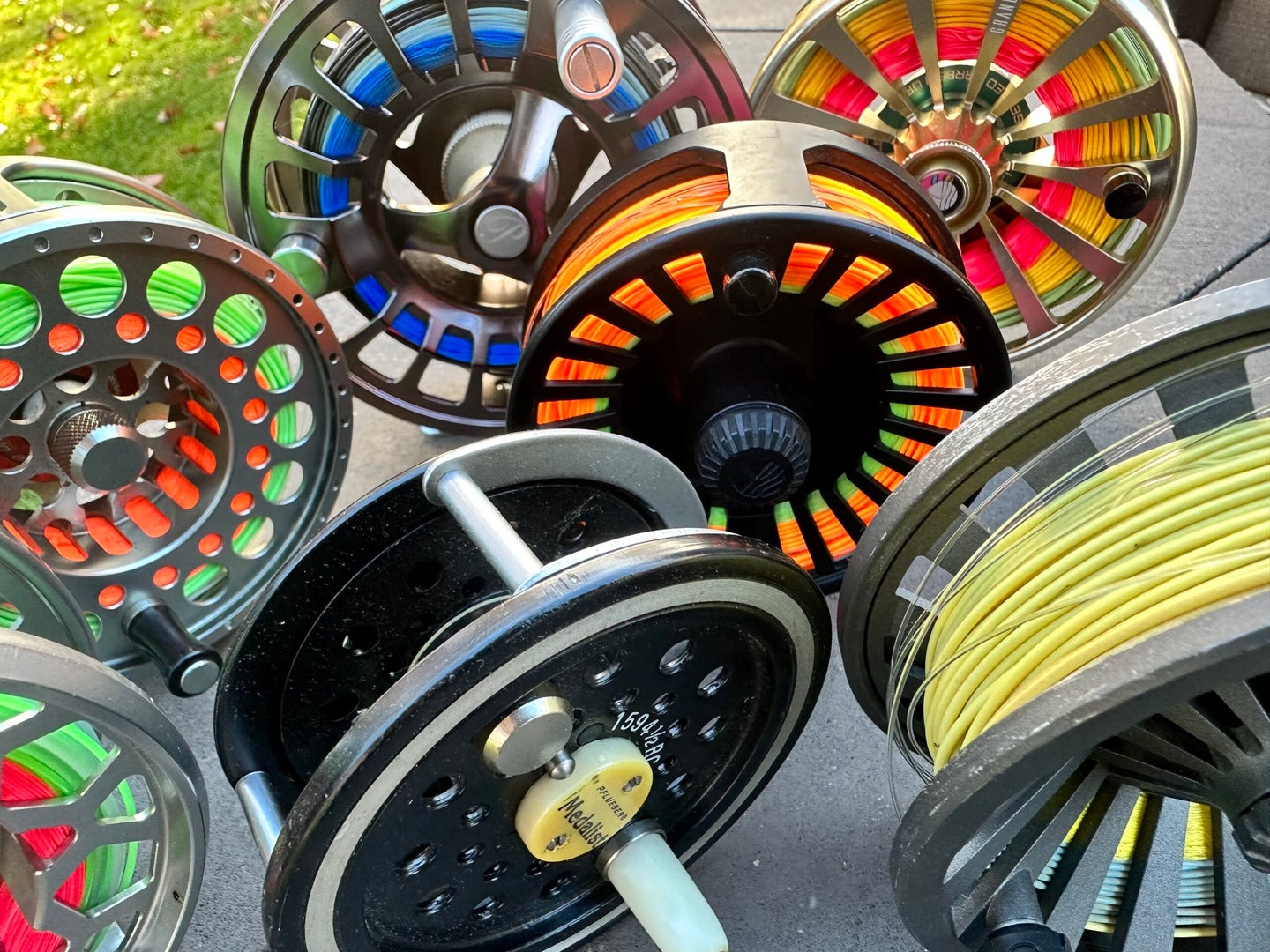 A collection of fly fishing reels arranged on a table.