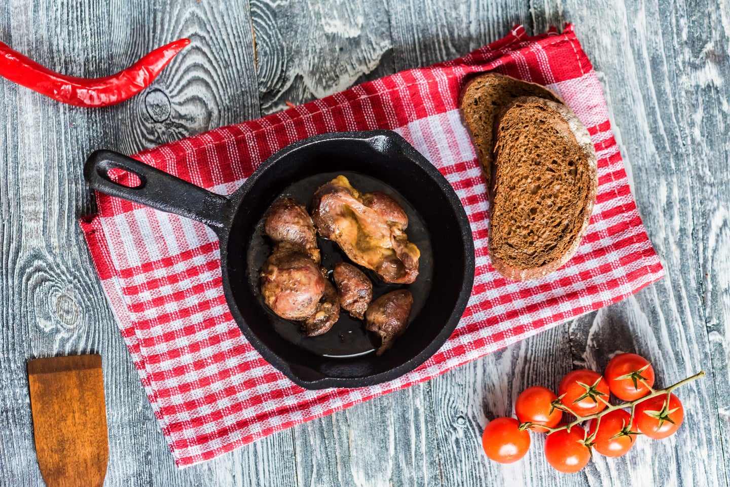 Turkey giblets cooked in a cast-iron skillet on a red-gingham napkin