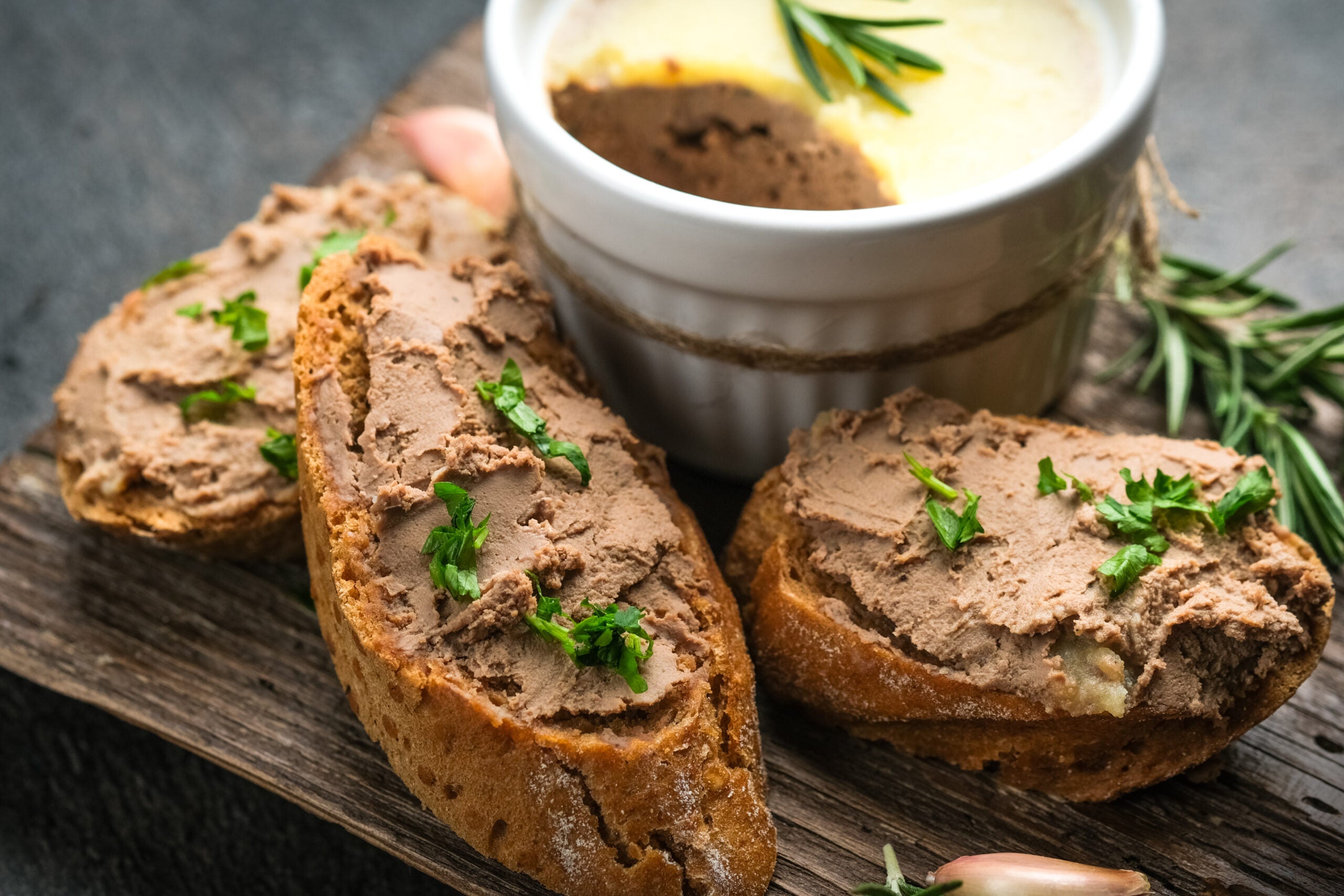 Homemade liver pate on toast served on a cutting board