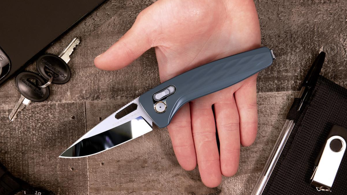 Man holding SOG One-Zero Pocket EDC Knife over desk