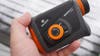 The orange and black body of a Maven rangefinder above a snowy deck. 