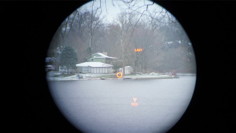 The view through a Vortex Diamondback rangefinder of the opposite shore of a lake on a snowy day. 