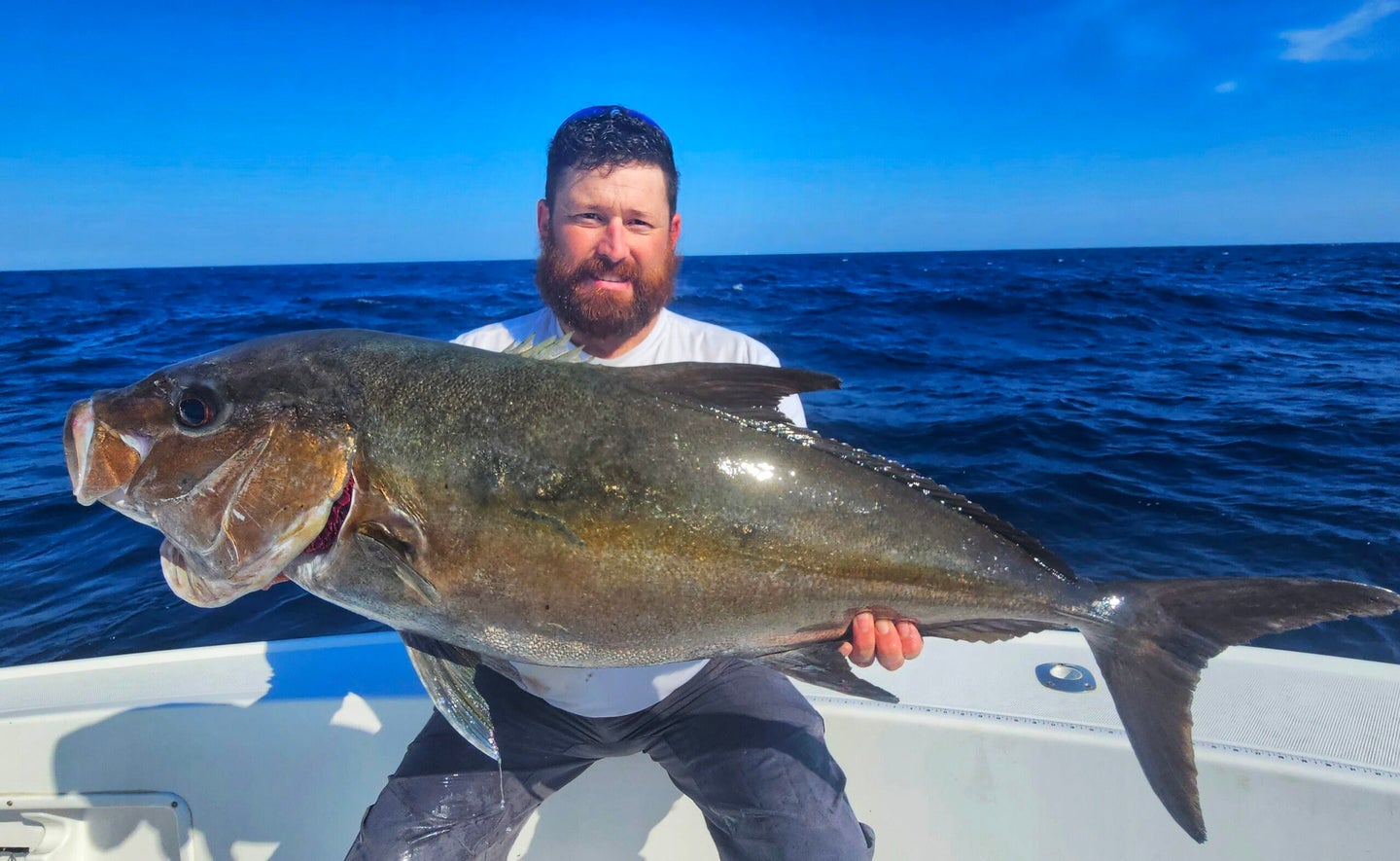 A Massachusetts fisherman poses with a North Carolina state record Almaco jack.