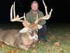 Hunter Davey Stuckey sits on the ground, posing with a huge whitetal buck he took