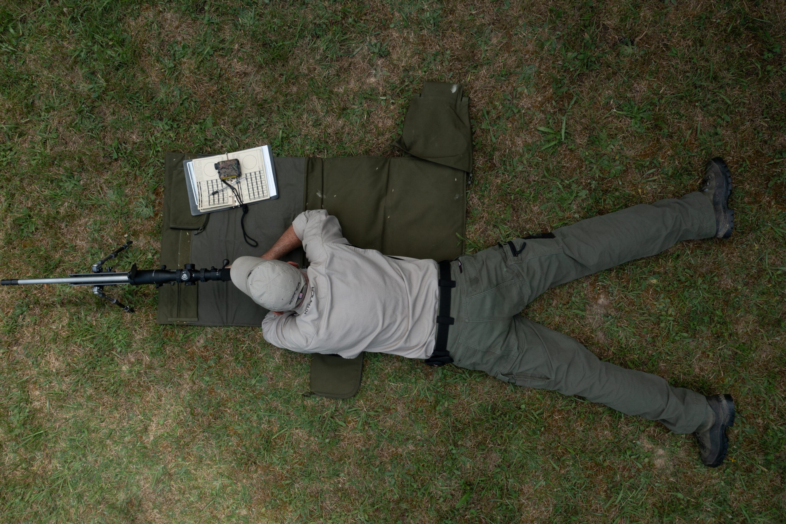 Man laying on the ground shooting a rifle from the prone position