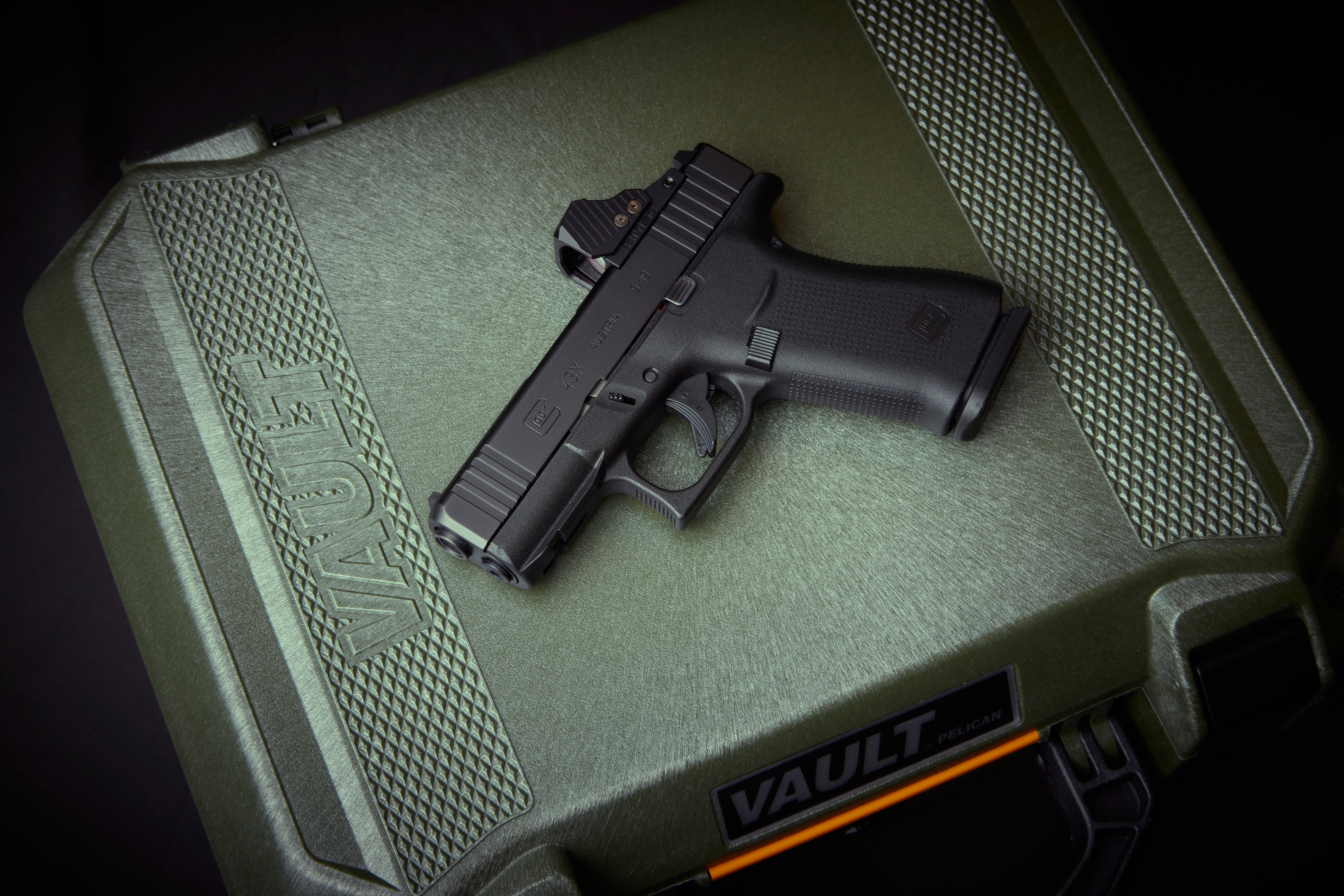 A Glock G43X MOS pistol lying on a green case