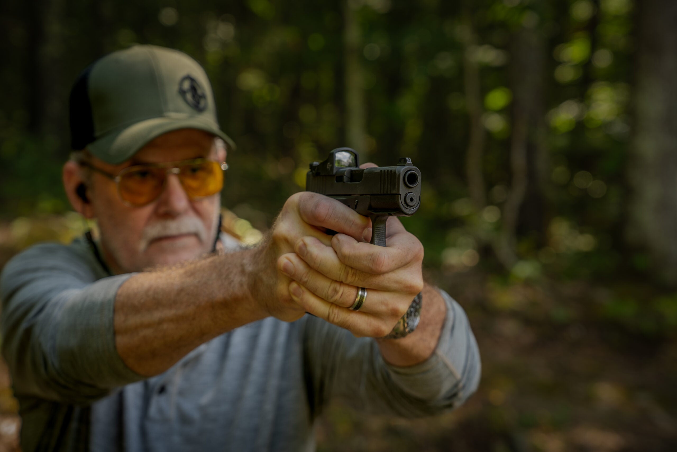 A shooter firing the Glock 43X MOS pistol on an outdoor range