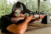 A man fires a rifle at a shooting range