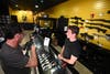 A man handles a rifle while talking to a clerk at a gun shop