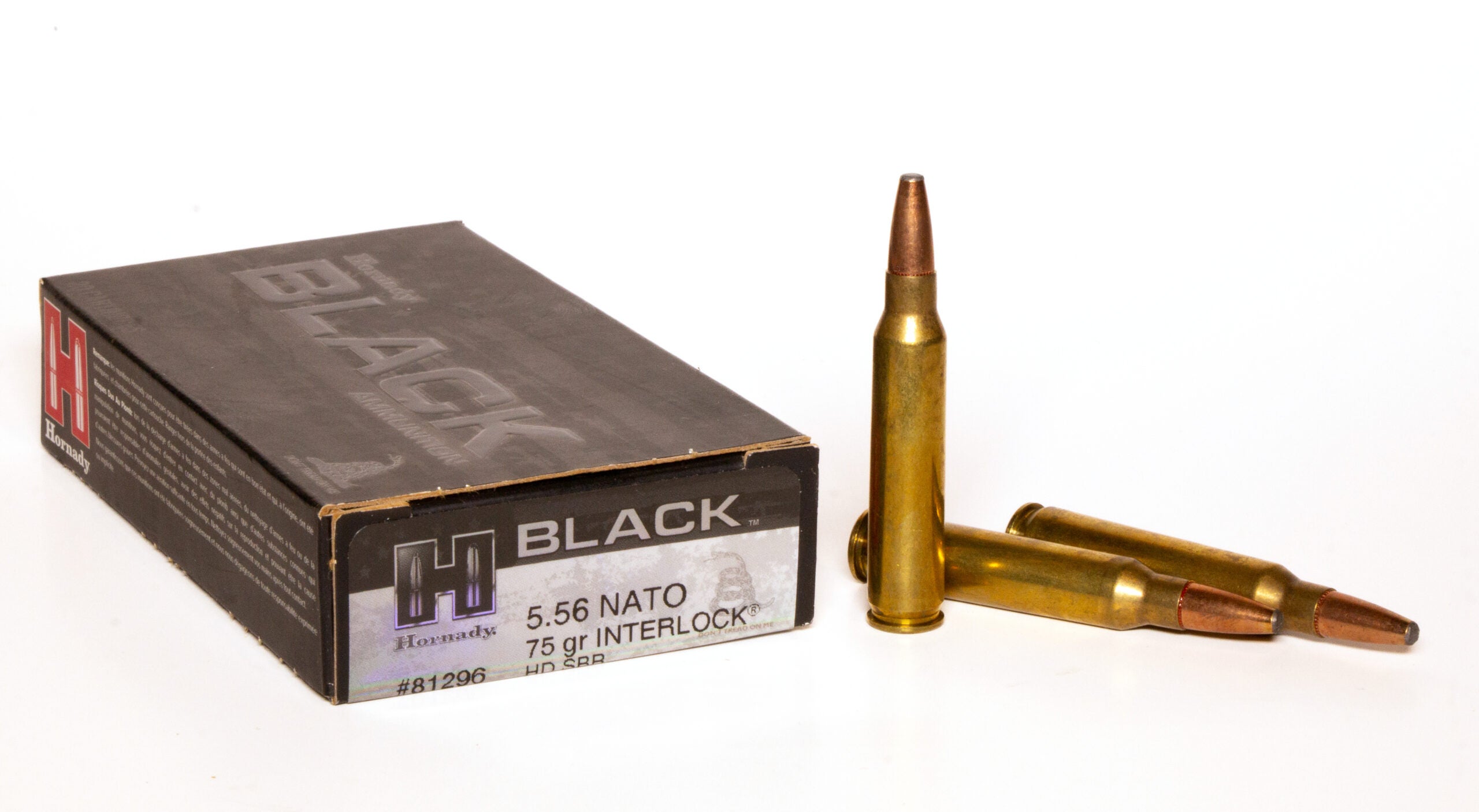 Box of 5.54 NATO ammo with three loose cartridges on white background