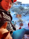 Female hiker camping in the winter with her dog