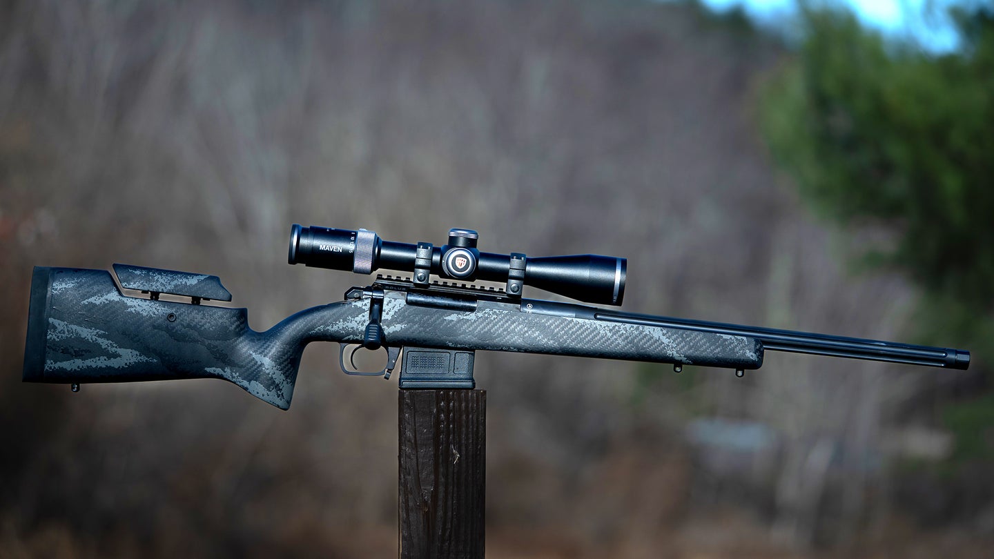 Aero Precision SOLUS Hunter rifle on a post with woods in background