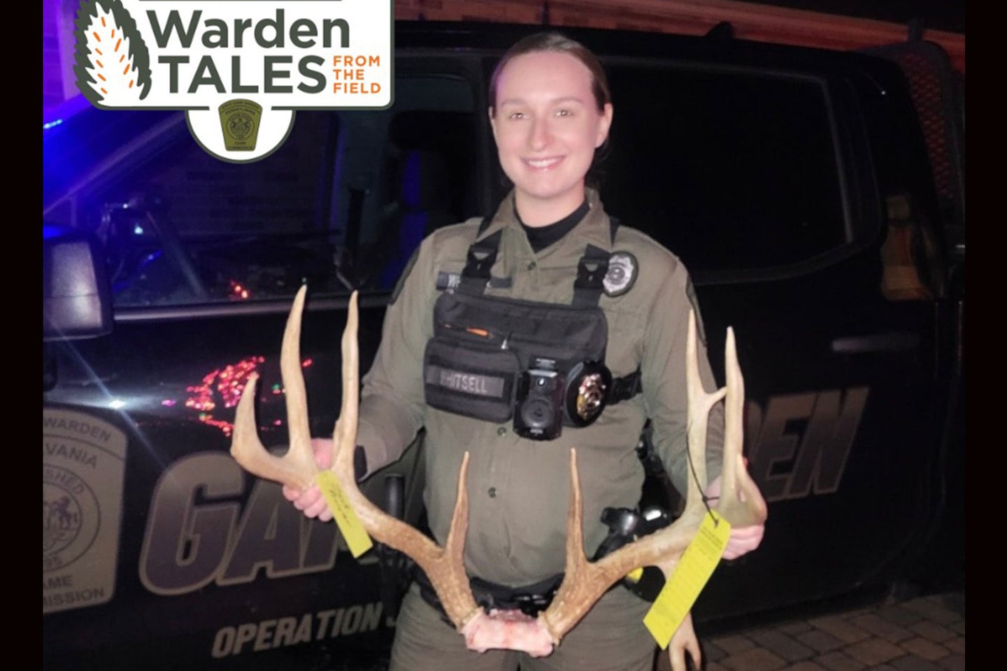 A game warden poses with a set of antlers confiscated from poachers in Pennsylvania.