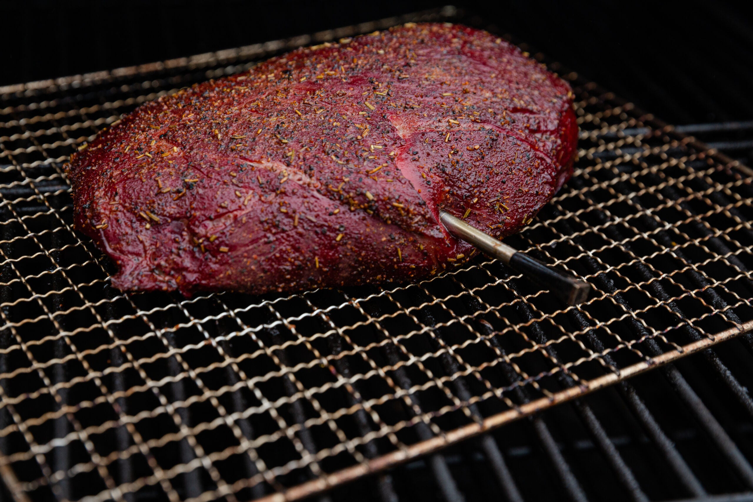 A venison top roast roast cooking in a smoker.