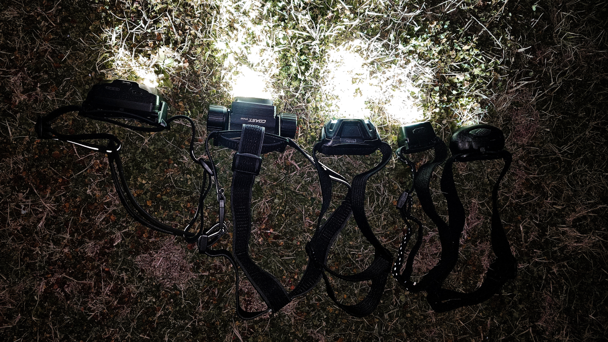 Headlamps lined up on grass at night turned on