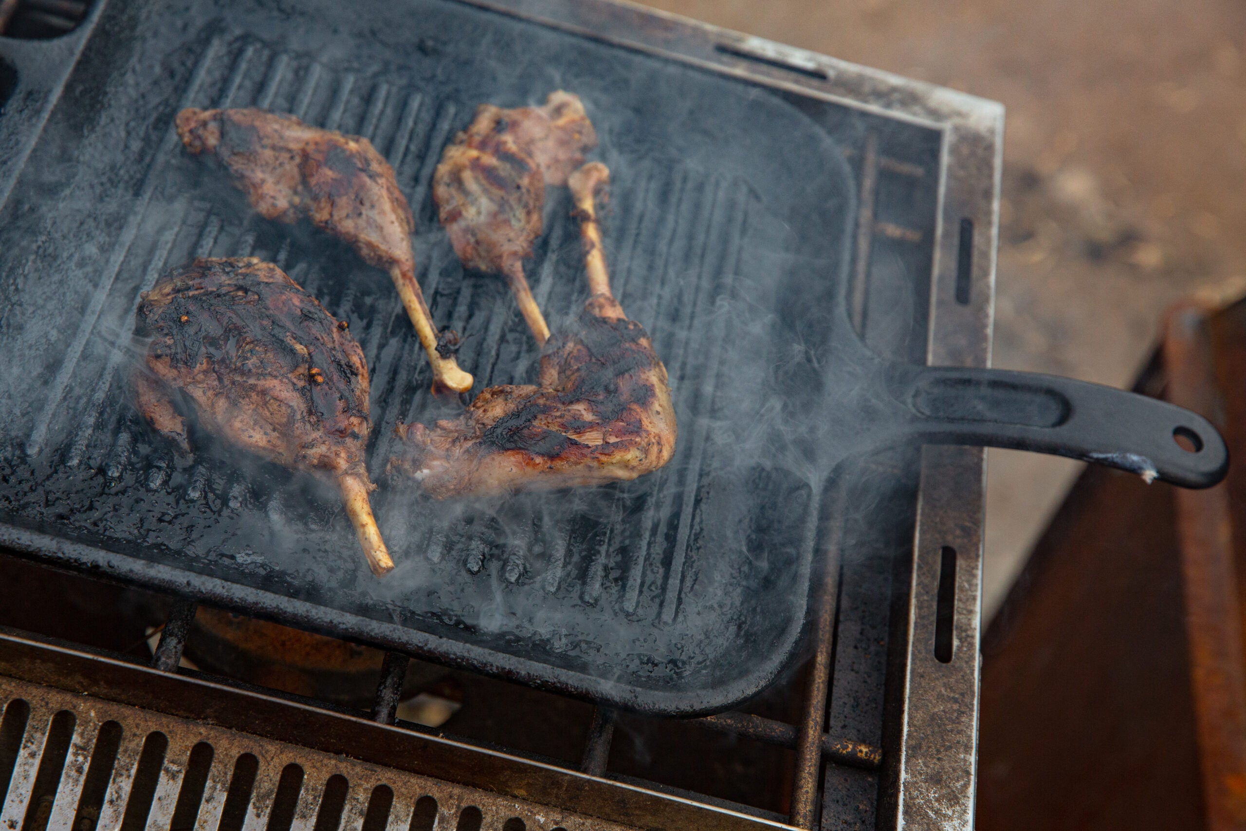 Goose legs cooking on a cast iron grill pan