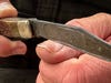 Checking the sharpness of a knife by running the blade across a thumb nail.
