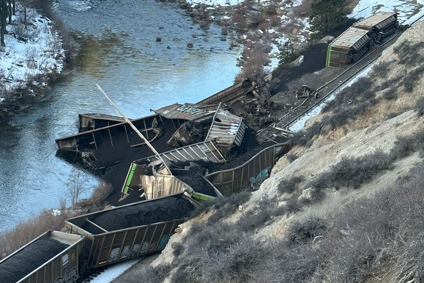 Train cars derailed into a protected river in California, spilling untold amounts of coal.