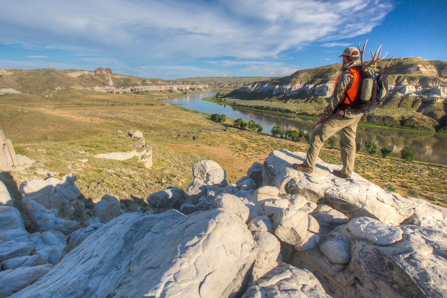 A mule deer hunter looks out from a vantage point above the Missouri River.